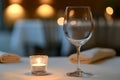 An intimate evening in a modern restaurant is complemented by an elegantly set table featuring candles and a wine glass Royalty Free Stock Photo