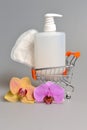 Intimate gel dispenser pump plastic bottle, sanitary towel in pushcart with orchid flowers