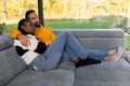 Intimate Moment of a Multiracial Couple Relaxing on a Sofa Royalty Free Stock Photo