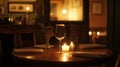 Romantic dinner table setting with wine glass, candle, and flowers in a dimly lit restaurant Royalty Free Stock Photo
