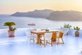 Intimate Romantic Places. Open Air Terrace Restaurant in Beautiful Oia Village on Santorini Island in Greece in Front of Volcanic Royalty Free Stock Photo