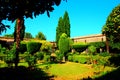 Intimate view of the San Giovanni in Venere gardens with red roses, green hedges and a crucifix