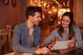 Intimately smiling millenial couple in restaurant