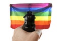 Intolerance violent representation of terrorist attack with hand pointing gun on proud gay holding flag