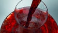 Intoxicant red beverage filling decanter slow motion. Wine forms waves glassware