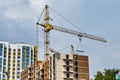 Construction of a multi-storey building, a crane lifts a concrete slab against the background of a newly built building. Royalty Free Stock Photo