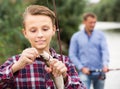 Intrested teenage boy releasing catch on hook fish Royalty Free Stock Photo