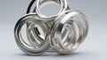 Intricate abstract sculpture of interlocking silver rings with reflective metallic surface and smooth gray background Royalty Free Stock Photo