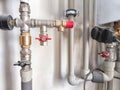 An intricate array of pipes and valves behind the scenes. Complex Plumbing Configuration Behind a Public Restroom Wall Royalty Free Stock Photo