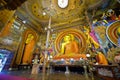 Intricate artwork & iconic large seated Buddha image in `earth touching` pose, interior Gangaramaya Temple, Colombo, Sri Lanka