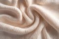 The intricate beige knitted fabric displays a structured geometric pattern illuminated by sharp directional lighting
