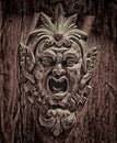 An intricate carved wooden face of a monsterous devil,