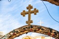 an intricate cross sits at the entrance to a cathedral at dusk