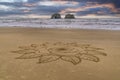 Intricate flower sand art on a beach.