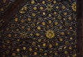 intricate golden arabesque intense relief on a dark wood close up decorated panel from Egypt