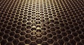 Intricate golden hexagonal metal mesh pattern with deep shadows and warm lighting creating a textured background Royalty Free Stock Photo