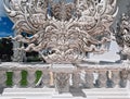 Intricate hand carving mirrored surfaces of facade of Chiang Rai white Temple