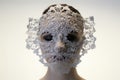 intricate lace mask on a white backdrop