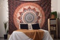 intricate mandala tapestry hanging on the wall of bohemian home