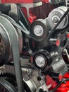 Close-up of a red engine showing pulleys and belts with detailed mechanics in a workshop setting Royalty Free Stock Photo