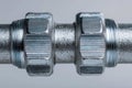 Close-up of a metallic mechanical connector with threaded nuts and textured surface, highlighting precision engineering and Royalty Free Stock Photo