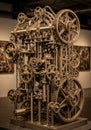 Intricate metal sculpture featuring interlocking gears, chains, and rods, resembling a Royalty Free Stock Photo