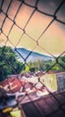 The intricate pattern of the wire mesh frames a stunning vista of Mount Singgalang, creating a visually striking composition