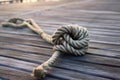 intricate sailing knot on weathered rope against wooden deck