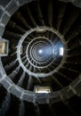 Intricate Stone Spiral Staircase with Natural Light Streaming Through Windows Creating Circular Royalty Free Stock Photo