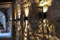 intricate wrought iron wall sconces lighting up a stonewalled meeting room