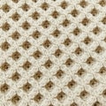 Intricately knitted fabric featuring a beige honeycomb pattern. The texture displays a Royalty Free Stock Photo