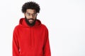 Intrigued and interested young creative male digital designer with beard and afro hairstyle in glasses and red hoodie