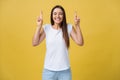 Intrigued woman in t-shirt praying with crossed fingers and looking away over yellow background Royalty Free Stock Photo