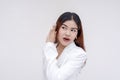 An intrigued young woman listening carefully with one hand on her ear. Isolated on a white background Royalty Free Stock Photo