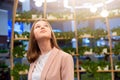 Female pose against green plants atmospheric lamps