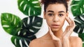 Contemplative african american woman with leaves in background