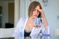 Introspective woman sitting deep in thought at a patio table