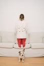 Introvert behavior. a girl in red tights and a jacket stands back to front on the couch. Royalty Free Stock Photo