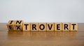 Introvert or extrovert symbol. Fliped cubes and changed the word `introvert` to `extrovert`. Beautiful wooden table, white