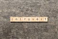 Introvert word written on wood block. Introvert text on table, concept