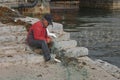 Inuit eskimo man preparing fresh fish on a market in Qaqortoq Greenland