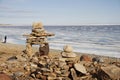 Inukshuk or Inuksuk on a rocky beach with ice on the ocean in late June in the high arctic