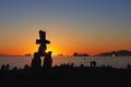 Inukshuk sculpture at sunset