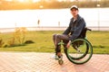 Invalid man sitting on a wheel chair and enjoying a walk outdoors Royalty Free Stock Photo