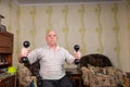 Invalid old man doing exercises with dumbbells