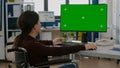 Invalid woman emplyee working on desktop computer green mock-up screen