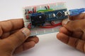 Inventor displaying his small graphic game controlled by set of buttons and micro controller attached to a breadboard Royalty Free Stock Photo