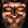 Inventor Hipster with Beard and Mustages in the Dark Room. Smiling Trickster. Royalty Free Stock Photo