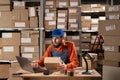 Inventory male worker to check order number on a parcel, using laptop computer, preparing a cardboard Box for postage Royalty Free Stock Photo