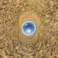 Inversion of blue little planet transformation of spherical panorama 360 degrees. Spherical abstract aerial view on yellow field
